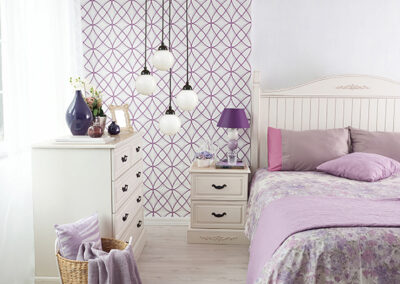 purple graphic accent wall wallpaper installation beside bed in bedroom