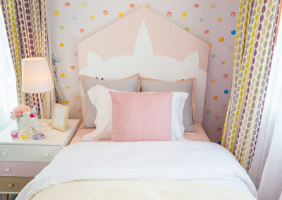 whimsical polka dot child's room wallpaper installation behind bed headboard